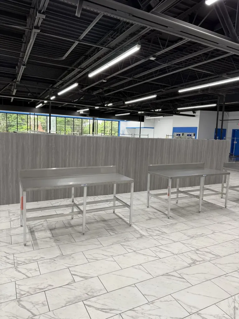 Stainless folding benches against timber-look partition panelling
