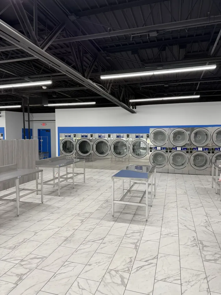 Wide central folding floor between the washer line and the stacked dryer wall
