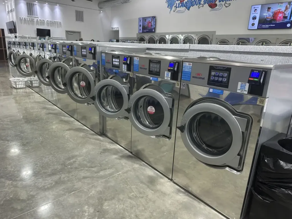 ClarusVibe touchscreens on 20 kg Wascomat washers beside the value-add centre