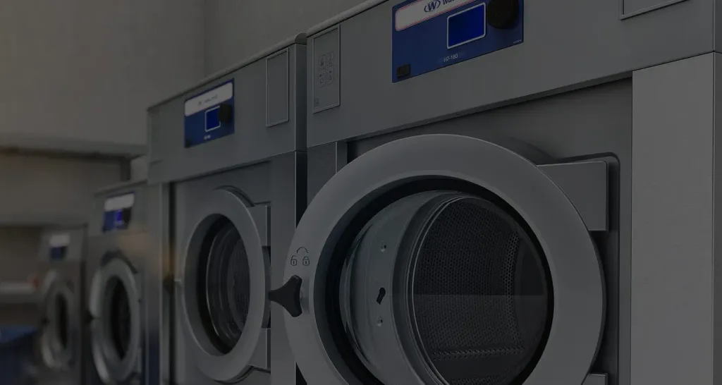 Row of Wascomat washers in a brightly finished laundromat