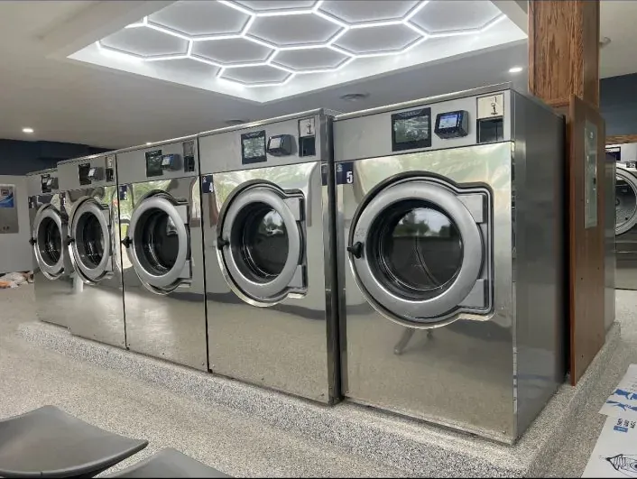 Wascomat Touch washers on granite plinths with timber column detail, designed by Jon Boike